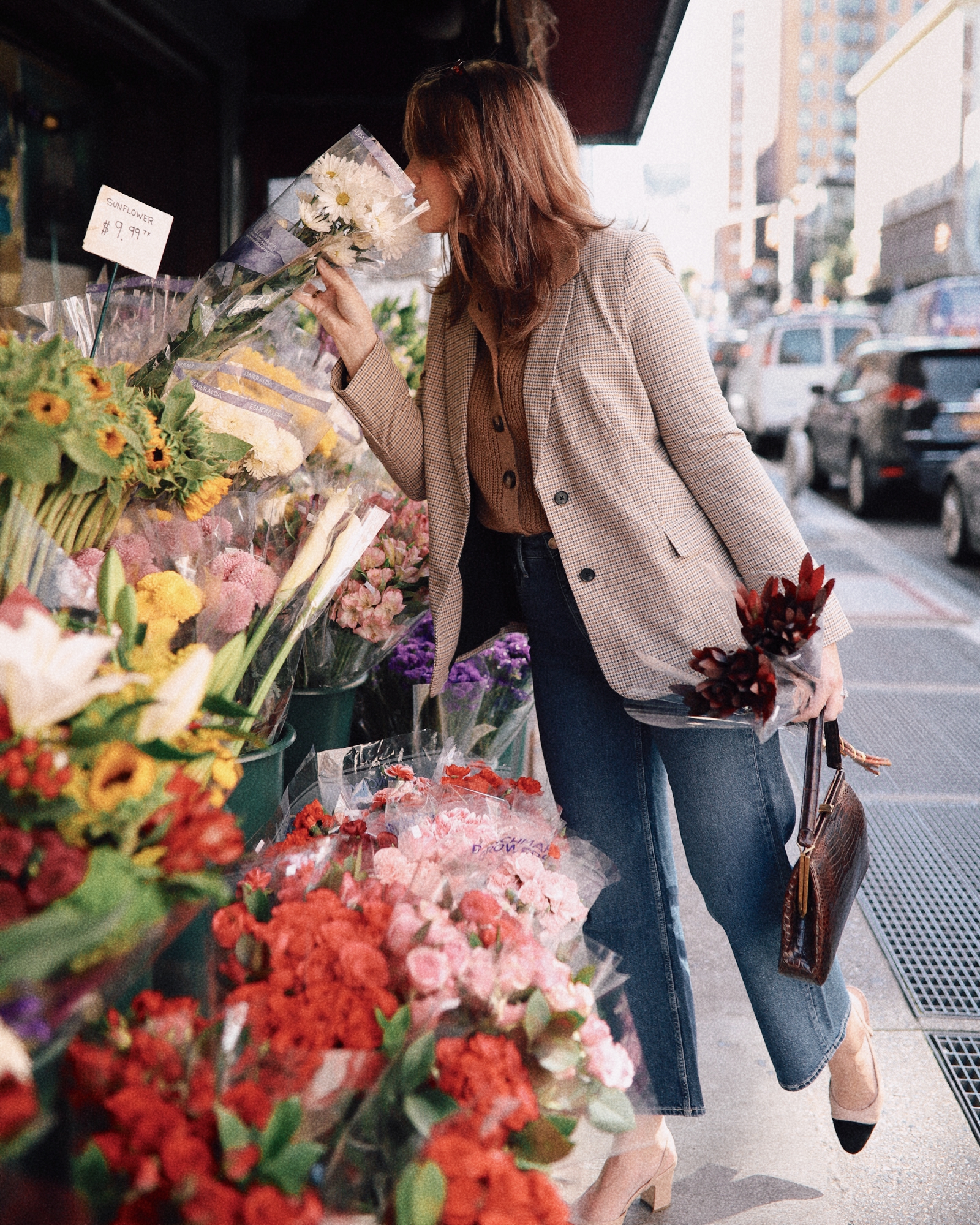 Anna smelling flowers in New York City.