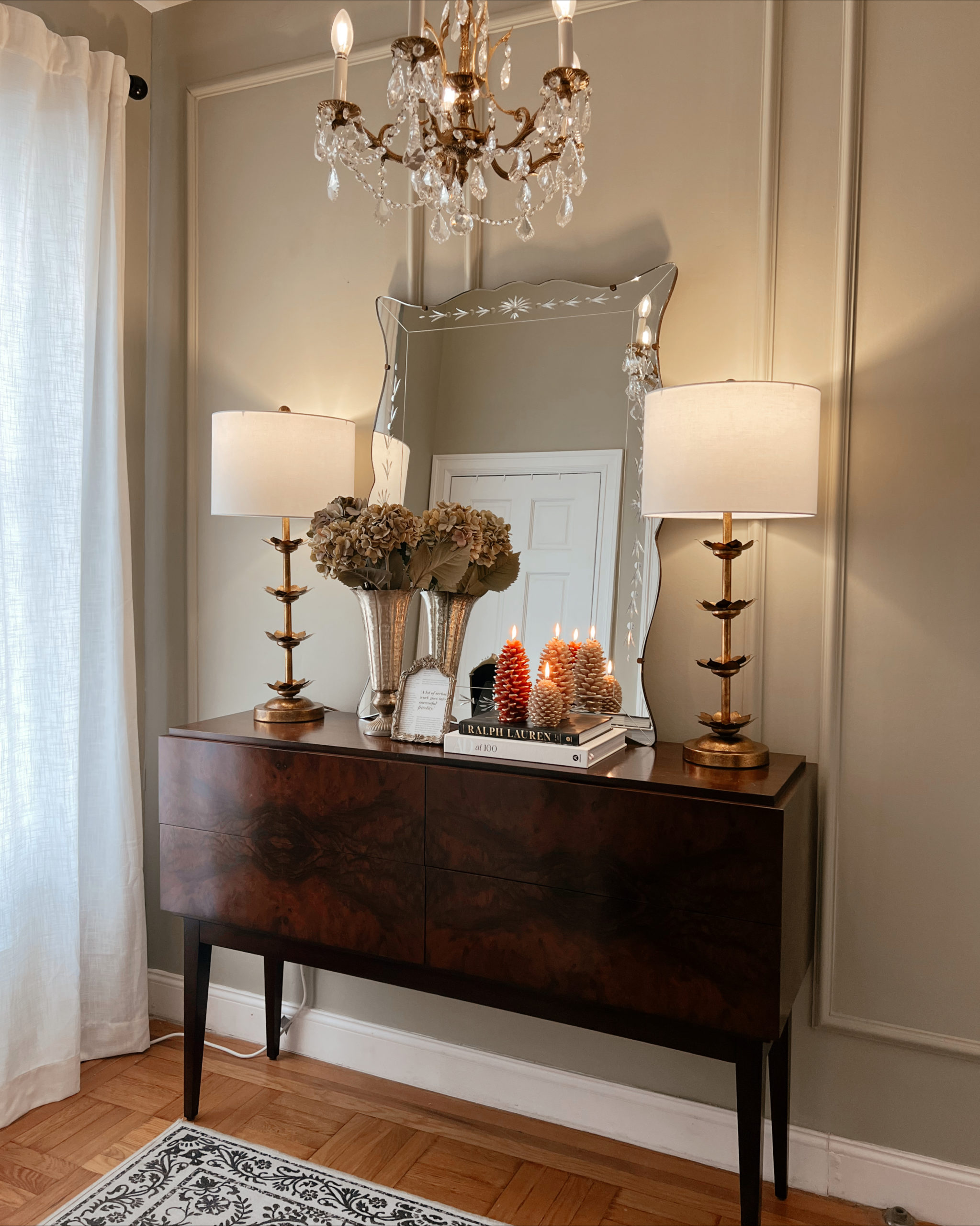 Anna's entryway with a mirror, two lamps, and decor in frame.
