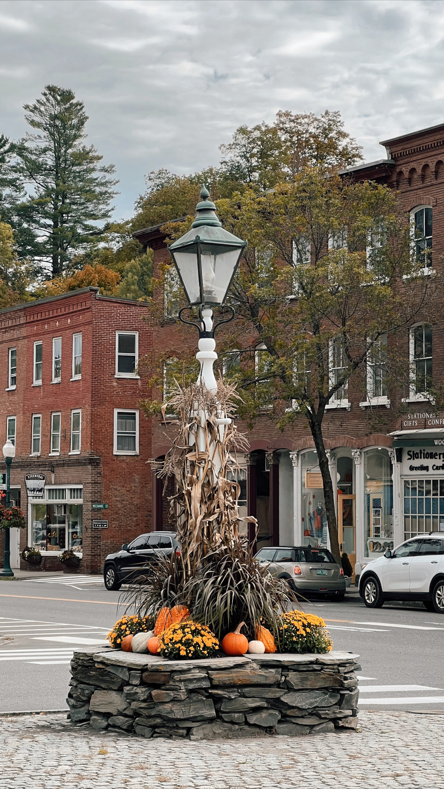 Photo of small town with pumpkins and fall decor around a lightpost.
