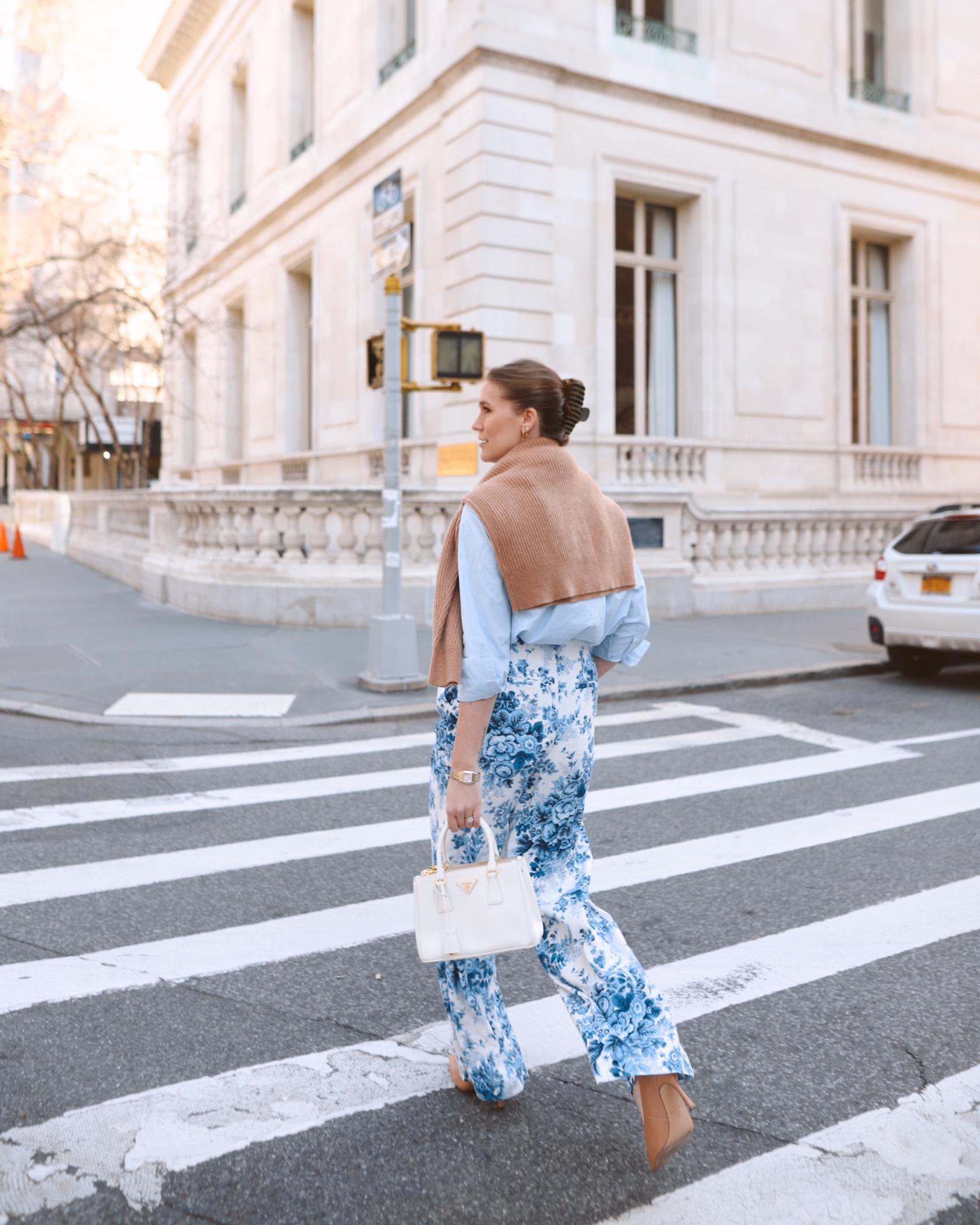 Anna wearing a blue and white outfit walking across the street.