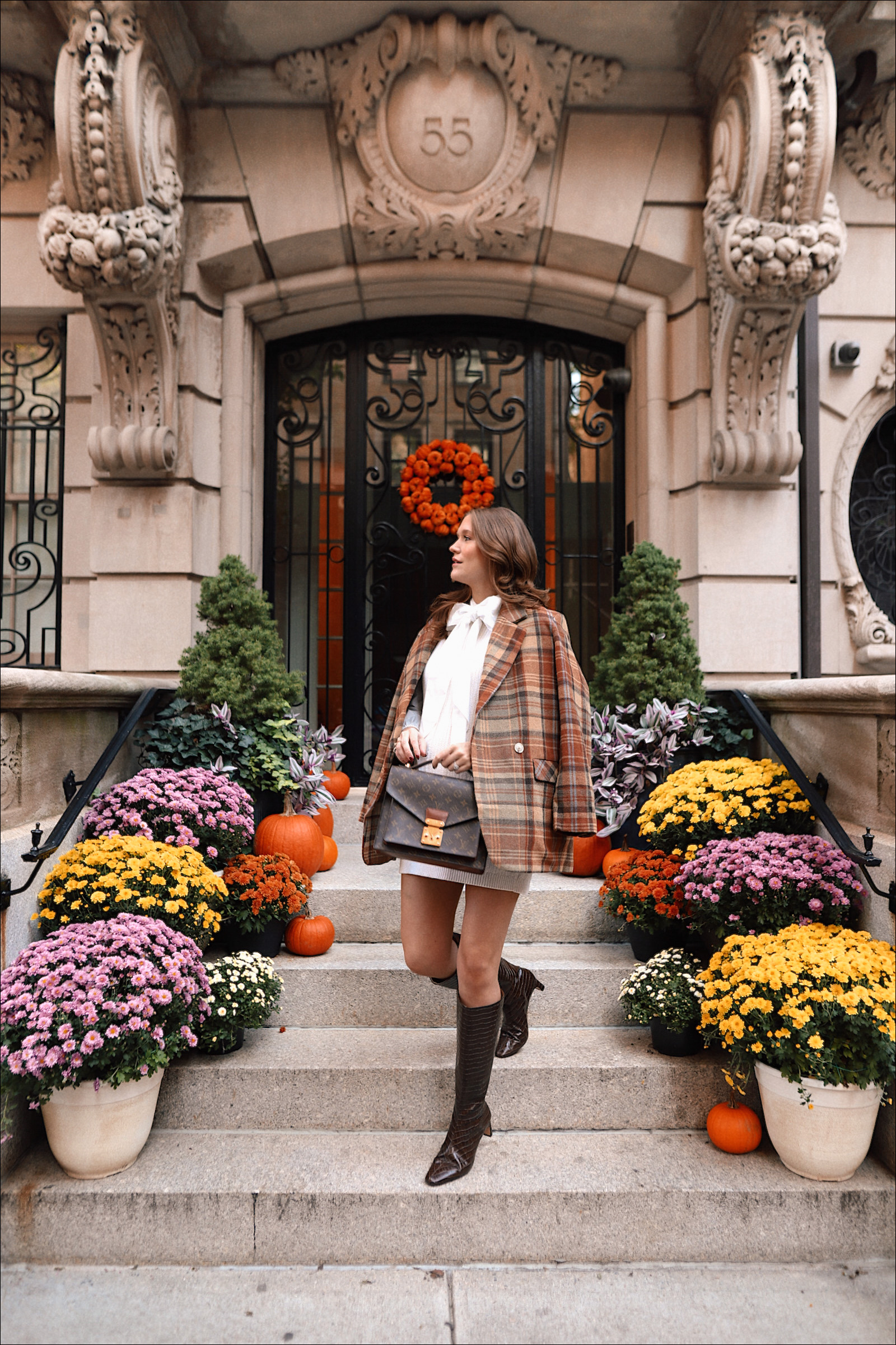 Anna on steps in New York City with fall flowers on the stairs.