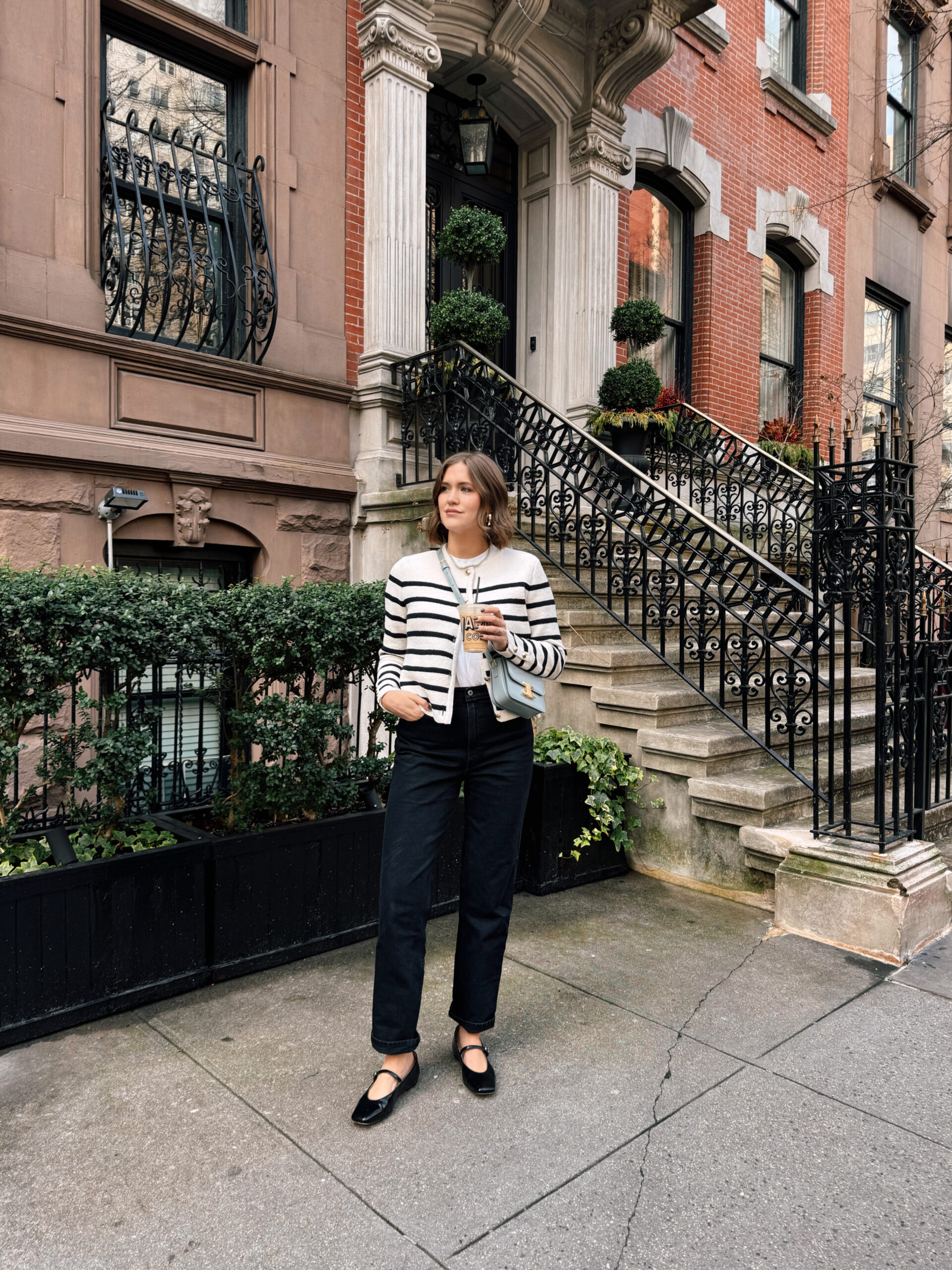 Anna wearing a striped black and white top and black pants on the streets of New York City.